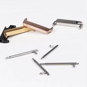 May include: A set of watch band spring bars and two watch band adapters. The adapters are made of metal and are available in gold and silver. The spring bars are made of metal and are silver.