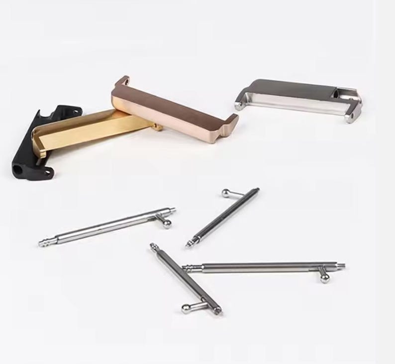 May include: A set of watch band spring bars and two watch band adapters. The adapters are made of metal and are available in gold and silver. The spring bars are made of metal and are silver.