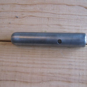 May include: A silver metal rod with a hole in the center.