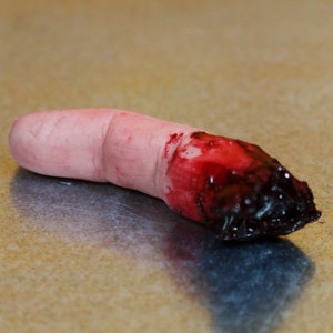 Peut inclure: Un doigt factice avec une blessure sanglante r&eacute;aliste &agrave; l'extr&eacute;mit&eacute;. Le doigt est de couleur chair avec une texture de peau d&eacute;taill&eacute;e, et la blessure est d'un rouge profond avec du sang caill&eacute; fonc&eacute;.