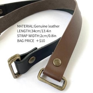 May include: A brown and black leather strap featuring brass-toned metal hardware and rivets. The text on the image reads: MATERIAL:Genuine leather, LENGTH:34cm/13.4in, STRAP WIDTH:2cm/0.8in, BAG PRICE +$10. The strap is designed with rectangular loops.