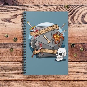 May include: A blue notebook with a spiral binding features a gray 20-sided die with a red 1 on it. The die is surrounded by a sword, an axe, and arrows. The die is also on fire and has blood dripping from it. The text "Well okay then" and "Guess I'll die" are written on the die. A white skull is below the die.