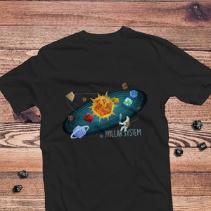 May include: A black t-shirt with a graphic of a solar system made of dice. The sun is a d20, the planets are d4, d6, d8, d10, d12, and a d20. The text "The Roll-ar System" is below the graphic.