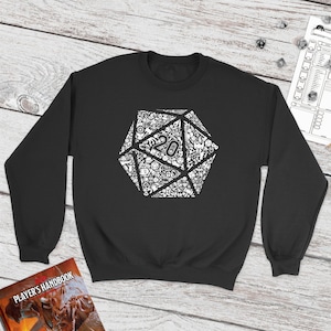 May include: Black sweatshirt with a white graphic of a twenty-sided die, or D20, made up of smaller dice and other gaming symbols. The die is centered on the sweatshirt.