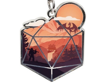 May include: A silver metal keychain shaped like a twenty-sided die with a fantasy landscape inside. The landscape features a mountain range, a castle, a river, a waterfall, a dragon, and a figure with a sword. The background is a sunset.