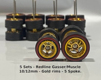 May include: A collection of miniature model car wheels. The wheels have gold rims, red sidewalls, and black tires. The text "Wheels" is displayed above the wheels. The text "5 Sets - Redline Gasser/Muscle 10/12mm - Gold rims - 5 Spoke" is displayed below the wheels.