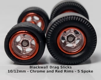 Peut inclure: Quatre roues Blackwall Drag Slicks avec jantes chromées et rouges. Les roues ont un design à 5 rayons et mesurent 10/12 mm. L'image comprend également le texte "Wheels" et "1:64 Scale".