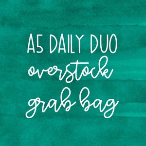 May include: White text on a teal watercolor background reads "A5 DAILY DUO overstock grab bag". The text is in a handwritten style, with the words stacked vertically.