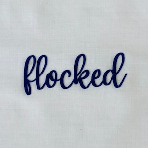 May include: A close-up of the word "flocked" written in a dark blue cursive font on a white background.