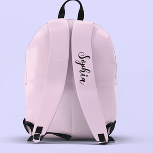 Puede incluir: Una mochila rosa con correas negras y una etiqueta de nombre negra que dice "Sophia".