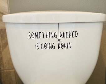 May include: White toilet tank with a black vinyl decal that reads "Something wicked is going down" with a spider hanging from the word "wicked".