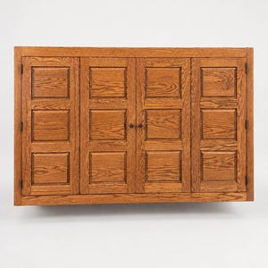 Front view of wall mounted oak TV cover cabinet with raised panel bi-fold doors in Chestnut finish.