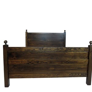 May include: A dark brown wooden bed frame featuring a horizontal plank headboard and footboard. The structure includes four square posts, each topped with a decorative spherical finial. The wood grain is visible throughout the stained finish.