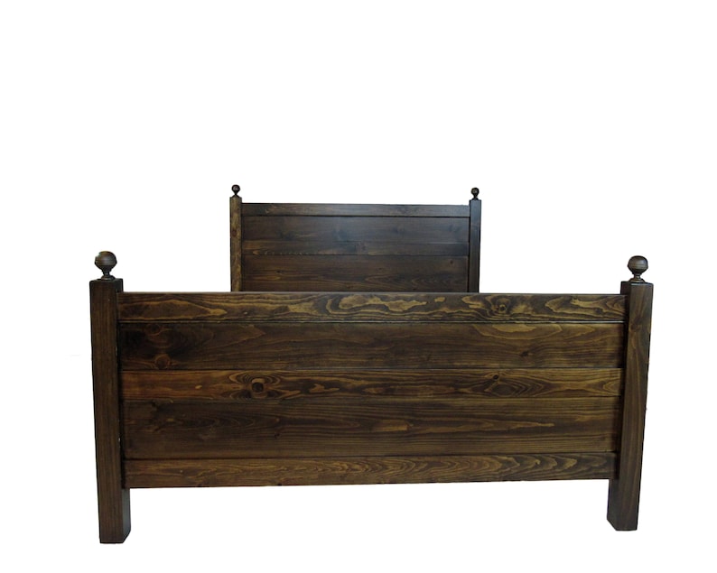 May include: A dark brown wooden bed frame featuring a horizontal plank headboard and footboard. The structure includes four square posts, each topped with a decorative spherical finial. The wood grain is visible throughout the stained finish.