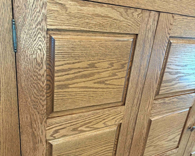 Detailed side-angle close-up of the Phoenix TV Cabinet showcasing the raised-panel door design and natural rustic oak grain.