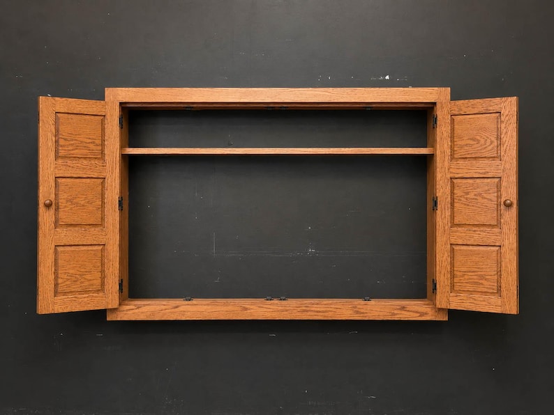 Open oak TV cover cabinet showing interior shelf and open-back design for wall-mounted television installation.