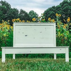 May include: White wooden headboard and footboard with a distressed finish. The bed frame is in a field of sunflowers.