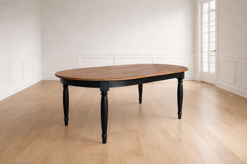 Handcrafted oval farmhouse dining table shown alone in a refined farmhouse dining room, highlighting its silhouette and solid wood construction.