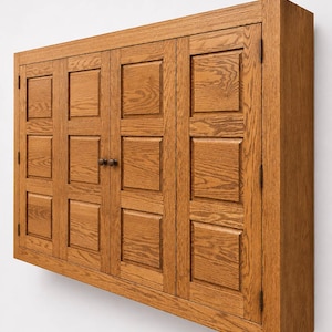 Angled perspective of handcrafted oak TV cabinet showing depth, raised panel doors, and solid wood construction.