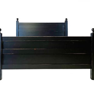 May include: A black bed frame featuring a tall headboard and a shorter footboard, both constructed with horizontal slats. The four corner posts are topped with spherical finials. The finish is a solid matte black with visible wear.