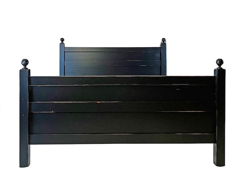 May include: A black bed frame featuring a tall headboard and a shorter footboard, both constructed with horizontal slats. The four corner posts are topped with spherical finials. The finish is a solid matte black with visible wear.