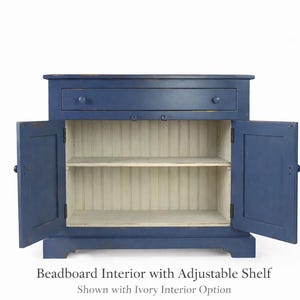 Farmhouse buffet cabinet interior with beadboard backing and adjustable shelf.