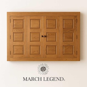 Handcrafted Phoenix TV Wall Cabinet in rustic oak with raised-panel bi-fold doors, displayed on a clean studio wall with the March Legend logo and sunflower emblem beneath.