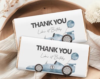 May include: Two white chocolate bar wrappers with blue race car designs and the text "Thank You Luke's 1st Birthday".