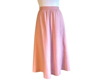 Könnte beinhalten: Ein rosa karierter Midirock mit hoher Taille und ausgestellter Silhouette.