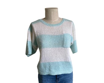 May include: A light blue and white striped knit sweater with short sleeves and a small pocket on the front.