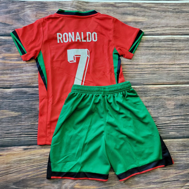May include: Red and green soccer jersey with the name "RONALDO" and the number "7" on the back. Matching green soccer shorts with black trim.