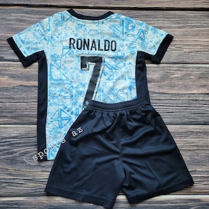 May include: A blue and white soccer jersey with black trim and the name "RONALDO" and the number "7" on the back. The jersey is paired with black soccer shorts.