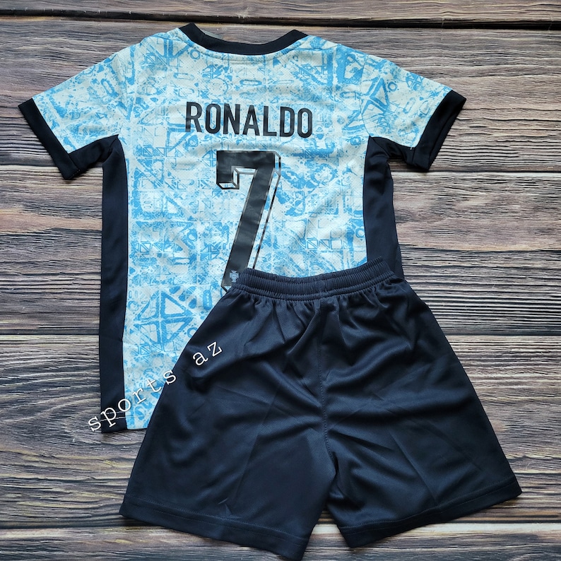 May include: A blue and white soccer jersey with black trim and the name "RONALDO" and the number "7" on the back. The jersey is paired with black soccer shorts.