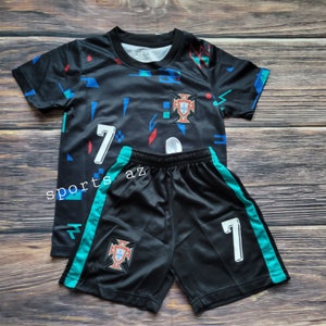 May include: Black and teal soccer jersey and shorts set with a geometric pattern, the number 7, and the Portuguese national team crest.