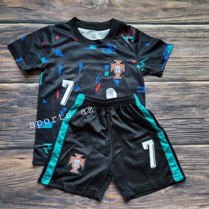 May include: Black and teal soccer jersey and shorts set with a geometric pattern, the number 7, and the Portuguese national team crest.