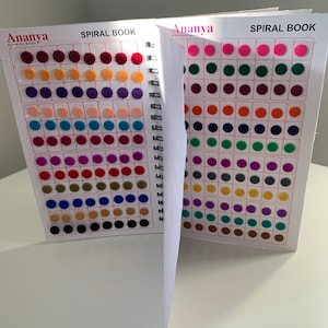 Puede incluir: Un libro en espiral con una variedad de círculos de fieltro de diferentes colores. El libro se titula "Ananya Kumkum Bindi" y "Spiral Book".