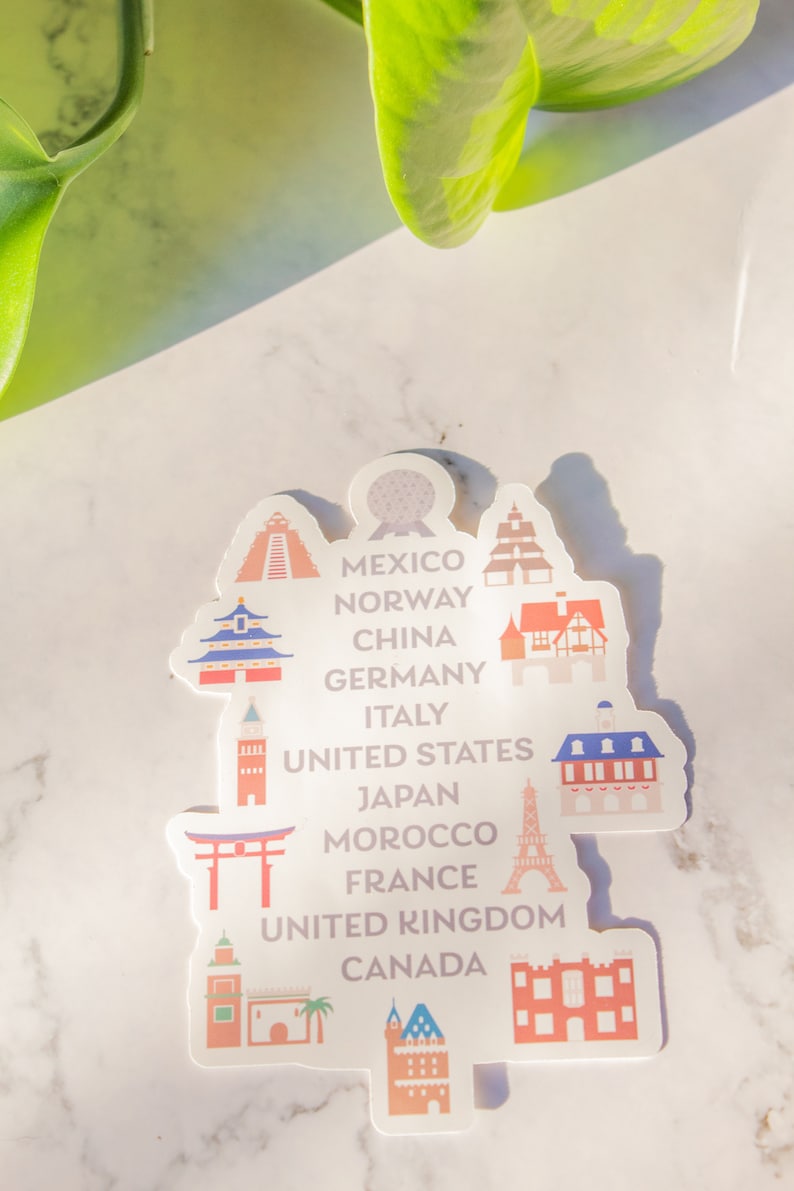 Op de afbeelding: Een witte sticker met kleurrijke illustraties van bezienswaardigheden uit verschillende landen over de hele wereld. De sticker bevat de tekst "Mexico, Noorwegen, China, Duitsland, Itali&euml;, Verenigde Staten, Japan, Marokko, Frankrijk, Verenigd Koninkrijk, Canada".