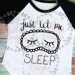 May include: White and black long-sleeved shirt with a black and white sleep mask graphic and the text "just let me sleep".