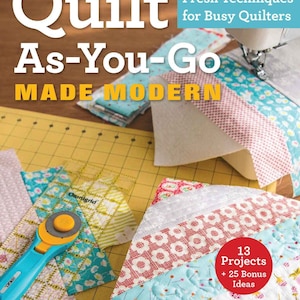 May include: A book cover with the title "Quilt As-You-Go MADE MODERN" in white text on a woodgrain background. The cover features a close-up of a quilt being made with colourful fabric scraps and a sewing machine. The text "Fresh Techniques for Busy Quilters" is in white text on a red background. The book cover also includes the text "13 Projects + 25 Bonus Ideas" in white text on a red circle.