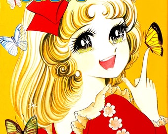 May include: A vintage Japanese manga comic book cover featuring a young girl with blonde hair and a red bow. She is wearing a red dress with white lace trim and is holding a butterfly. The title of the comic is "オリビア" and the author is "藤原栄子先生".