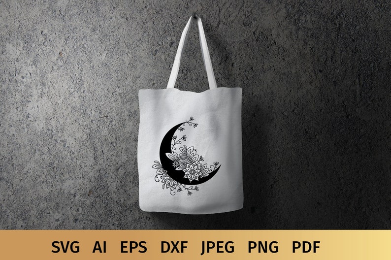 May include: A white tote bag with a black and white crescent moon design. The moon is decorated with intricate floral patterns.