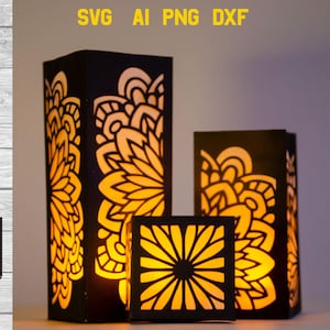 Puede incluir: Tres faroles de papel negro con intrincados diseños recortados. Los faroles están iluminados desde el interior, proyectando un cálido resplandor. El farol más grande presenta un gran diseño floral, mientras que los faroles más pequeños tienen un diseño floral más pequeño.