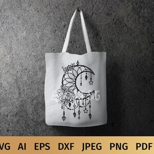 May include: A tote bag with a black and white design of a crescent moon with a floral pattern and hanging stars and beads. The design is reminiscent of a dreamcatcher.