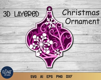 May include: A layered Christmas ornament design in shades of purple and white, featuring a snowflake and floral pattern. The ornament has the text "3D Layered Christmas Ornament". The design is suitable for crafting projects.