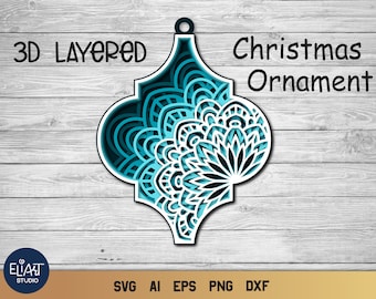 Op de afbeelding: Een gelaagde 3D kerstversiering in een turquoise en wit ontwerp. De versiering heeft een decoratief patroon en de tekst "3D Layered Christmas Ornament". De afbeelding bevat ook de tekst "EllArt Studio" en bestandstype afkortingen.