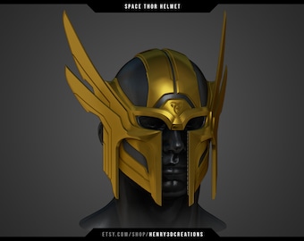 May include: A gold and black space helmet with a winged design. The helmet has a visor and a symbol on the front.