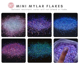 May include: Six small containers of iridescent glitter flakes in various colors, including purple, blue, and green. The glitter is labeled "Mini Mylar Flakes" and is described as solvent resistant and colorfast.