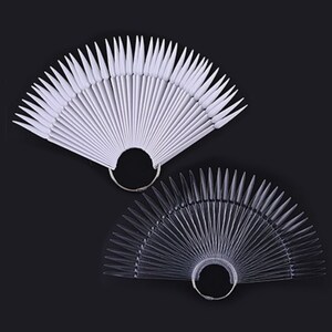 May include: Two sets of nail tips, one white and one clear, arranged in a fan shape. Each set has a metal ring at the base.
