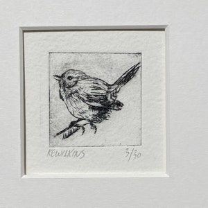 May include: A black and white etching of a small bird perched on a branch. The artwork is signed "KEWILKINS" and numbered "3/30".