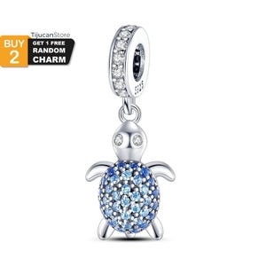 Pode incluir: Um charm de prata em forma de tartaruga com uma concha de cristais azuis e azul claro. O charm tem um anel com cristais transparentes e o texto "S925".